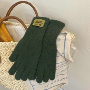 Dark green knitted long five-finger gloves cozy winter warm soft knit apparel clothing detail
