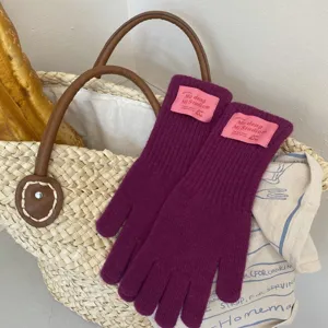 Cozy purple knit gloves with cute pink label, warm winter five-finger design for daily wear.