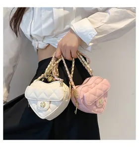 Close-up detail van gewatteerde hartvormige crossbodytassen met kettingriemen en camelliaslot.