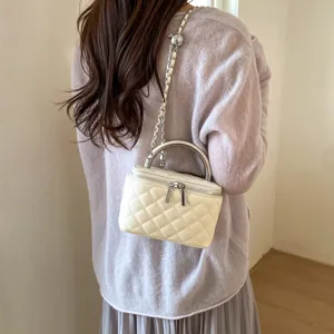 Quilted chain shoulder bag for women, stylish crossbody vanity handbag with top metal handle.