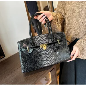 Elegante glänzende Handtasche mit Schlangenmuster und goldenem Metallschloss für Damen.