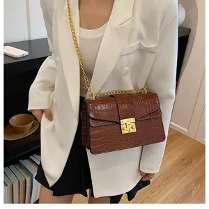 Detailed view of women's brown crocodile pattern chain shoulder bag with metal lock.