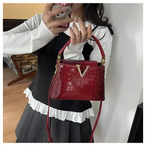 Red crocodile pattern top handle shoulder bag, stylish detail shot showing metallic V clasp.