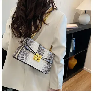 Detail shot of the stylish crocodile pattern chain shoulder bag with luxury golden lock hardware.