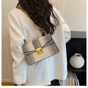 Detail shot showing the crocodile pattern texture and gold chain of the stylish shoulder bag.