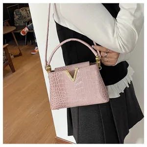 Pink crocodile pattern handbag with metal V decor, versatile stylish crossbody shoulder bag.