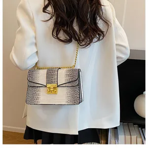 Detailed close-up view of the fashionable crocodile pattern chain shoulder bag with gold metal lock.