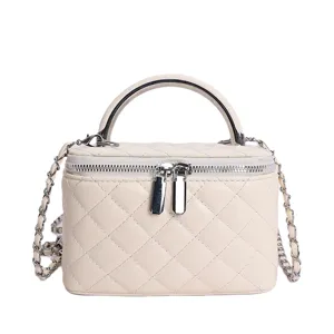 Beige quilted chain top-handle crossbody bag, stylish women's mini cosmetic vanity handbag.
