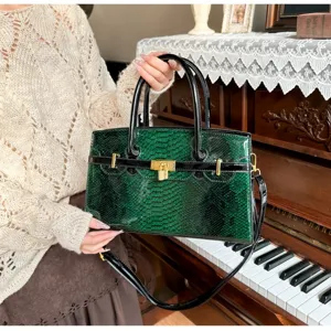 Elegante grüne Handtasche mit Schlangenmuster, goldfarbenen Beschlägen und Tragegriff.
