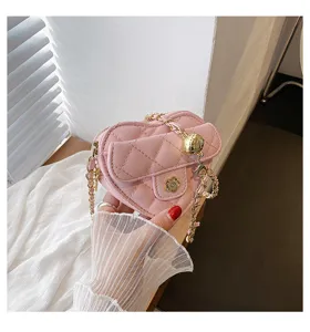 Chique roze gewatteerde hartvormige crossbodytas met goudkleurige ketting en bloemsluiting.