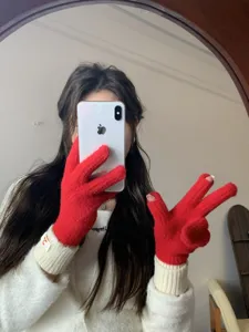 Detail view of women's red and white color-block knitted gloves, cozy winter hand warmers.