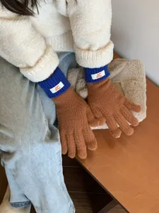 Detail shot of women contrast knit gloves, stylish brown blue thermal touch screen winter gloves.
