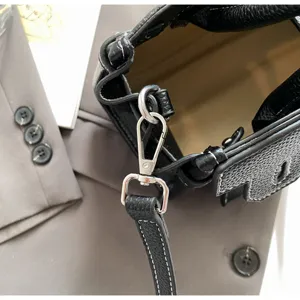 Black leather handbag detail shot with silver hardware and contrast stitching for chic commuting.