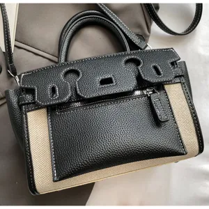Details of the color-block handbag showing canvas, leather texture and retro hardware.