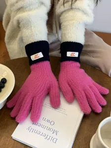 Cozy pink knit gloves with black cuffs detail showcasing fine texture and warm winter style.