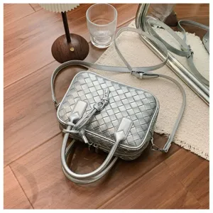 Silver woven leather shoulder bag detail shot, featuring metallic texture and casual style.
