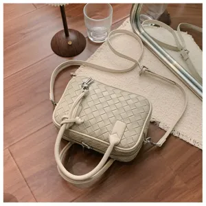 Beige woven leather crossbody bag detail, showcasing intricate intrecciato texture design.