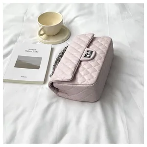 Close-up of pink quilted chain shoulder bag featuring metal turn-lock and elegant strap.