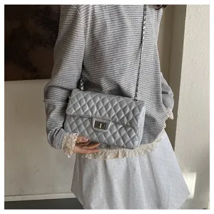 Grey quilted chain shoulder bag detail showing stylish diamond pattern and metal strap.