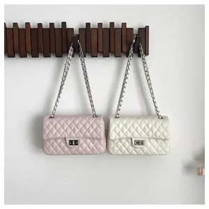 Chic quilted shoulder bag hanging on a wooden hook, showing exquisite chain strap detail.