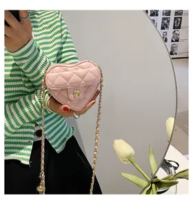 Mini roze gewatteerde hartvormige schoudertas met kettingriem en bloemvormige sluiting.