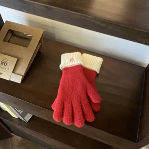 Detailed view of women's red contrast knit gloves with cozy white cuffs for winter warmth.