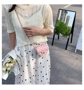 Chique roze gewatteerde hart-schoudertas detailweergave met elegante ketting en bloemsluiting.
