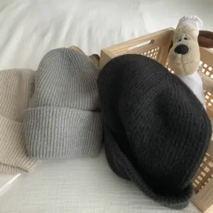 Vue détaillée de bonnet d'hiver en tricot douillet aux tons neutres, tissu doux et chaud.