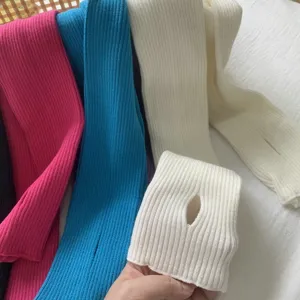 Gros plan détaillé de mitaines en tricot côtelé de plusieurs couleurs montrant leur texture.