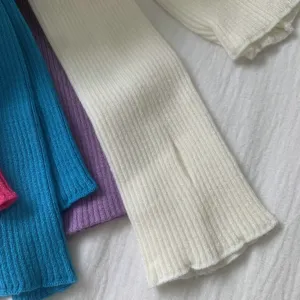 Vue détaillée de manchons tricotés, matière côtelée douce, accessoire coloré polyvalent.