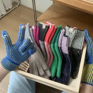 Detailed view of women knitted fingerless gloves featuring colorful striped patterns for cold days.