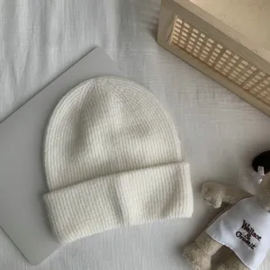 Vue détaillée du bonnet tricoté blanc pour femmes, bord rabattu classique couleur unie bonnet chaud.