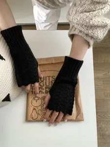 Vista detallada de guantes de punto sin dedos con textura de lana suave y patrón de trenzas.