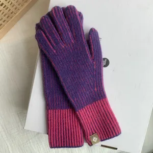 Fashionable knitted winter warm gloves for women, stylish purple pink colorblock design.