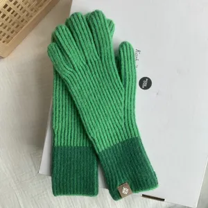 Detailed close-up view of green color-blocked ribbed knit fingerless gloves for autumn.
