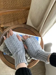 Guantes de punto sin dedos en detalle, suave textura de lana gris para el invierno.