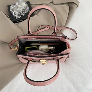 Stylish pink crocodile pattern crossbody bag with top handle, chic contrast design for women.