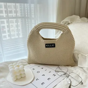 Detailansicht der beige Strickhandtasche mit feiner Textur in gemütlicher Schlafzimmeroptik.