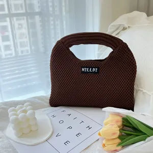 Braune Strick-Handtasche im Detail, zeigt die weiche Textur und das individuelle Etikett.