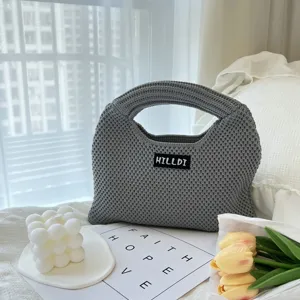 Detaillierte Ansicht der grauen Stricktasche, minimalistische gewebte Tasche mit Textur.