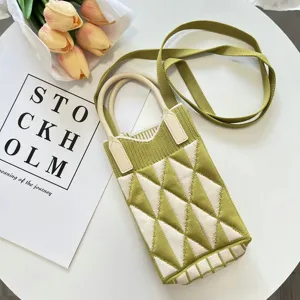 Detailansicht der grün-weißen Strick-Handtasche mit Rautenmuster, Henkeln und langem Schulterriemen.