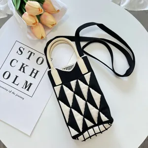 Detailansicht der schwarz-weißen Mini-Handy-Umhängetasche aus Strick mit Rautenmuster.