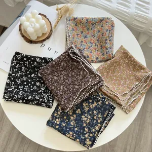 Vue détaillée d'un foulard carré floral en coton et lin avec élégante bordure en perles.