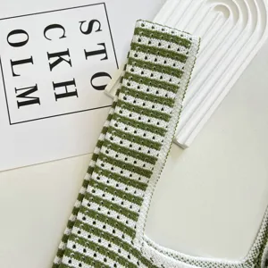 Détail de sac gilet en tricot ajouré rayé vert et blanc, design élégant et très respirant.