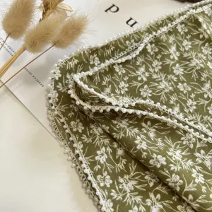 Détail de petit carré en lin de coton, foulard floral fin avec un bord de perles élégant.