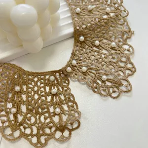 Detailed view of elegant beige lace fake collar with white faux pearls, hollow-out floral design.