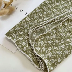 Vue de détail du foulard carré léger en lin et coton à fleurs avec bordure en perles.