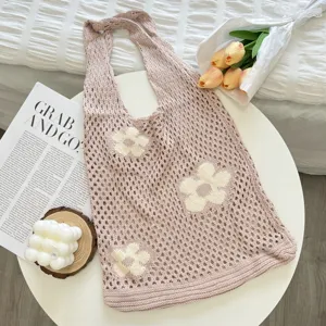 Knitted floral tote bag detail showing the soft hollow-out knit texture and cute white flower pattern.