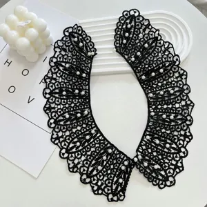 Detailed close-up of elegant black lace detachable collar decorated with delicate white pearls.
