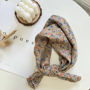 Gros plan détaillé du foulard fleuri délicat avec une bordure perlée élégante et chic.